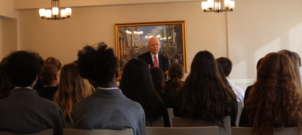 Brian Lamb pictured in the center, lecturing to students, who are sitting in the seats in front of him, with their backs turn